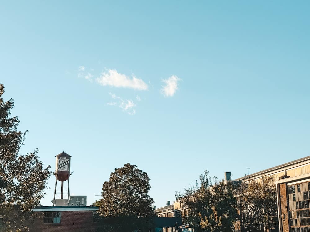 A view of the iconic silo at The Factory at Franklin, one of the best things to do in Franklin, against the boue sky and framed by lush trees