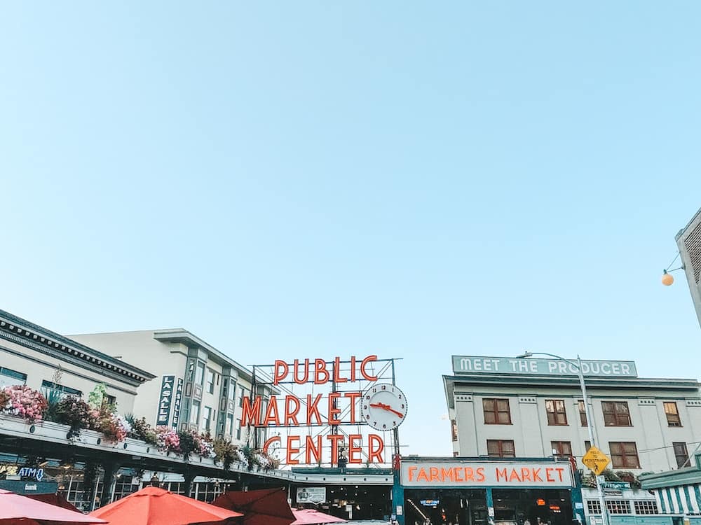 The neon red Pike Place Public Market sign and tops of the buildings in Seattle, Washington – one of the best places to visit in the USA in July.