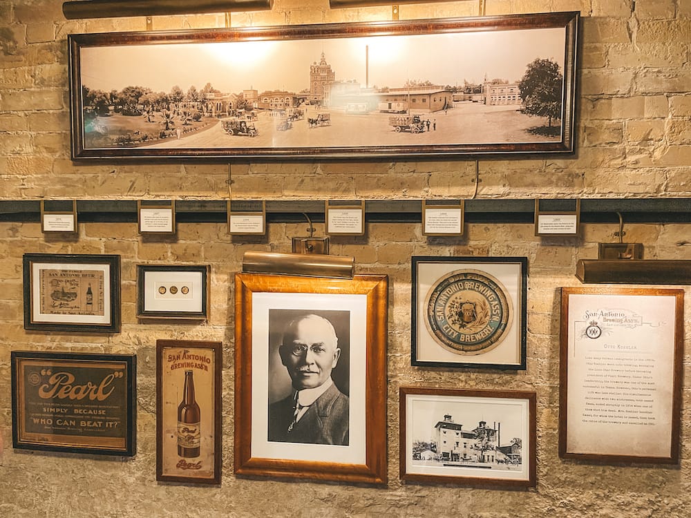 A timeline of the history of the Pearl in San Antonio, with framed photos of Otto Koehler, a beer bottle, historic buildings, letters, and more.