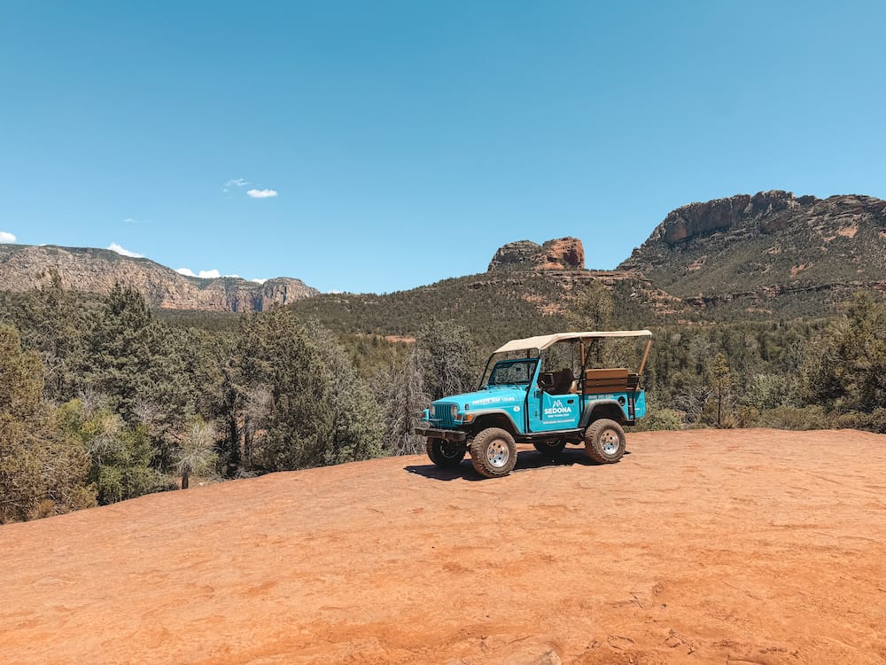 A blue Jeep sitting on the red rocks in Sedona after an off-roading tour, one of the best things to do in Sedona.
