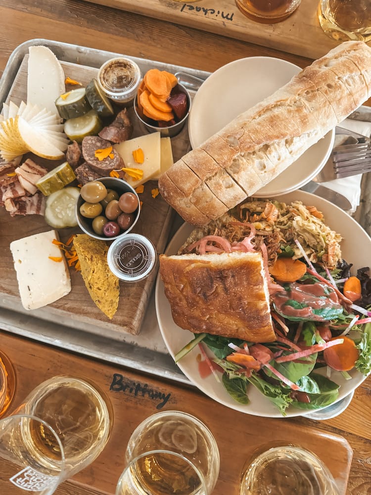 A spread of meats, cheeses, olives, bread, and other charcuterie items on a tray at Finger Lakes Cider House.