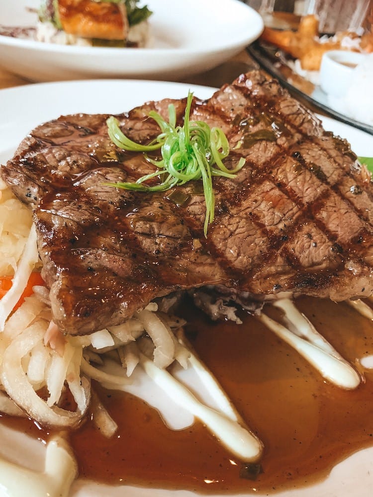 A steak sitting on a white plate.