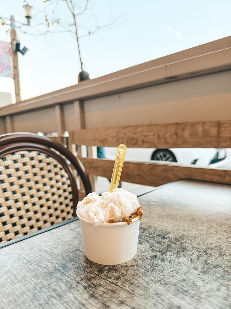 A cup of gelato sits on a porch table at an Italian bistro.