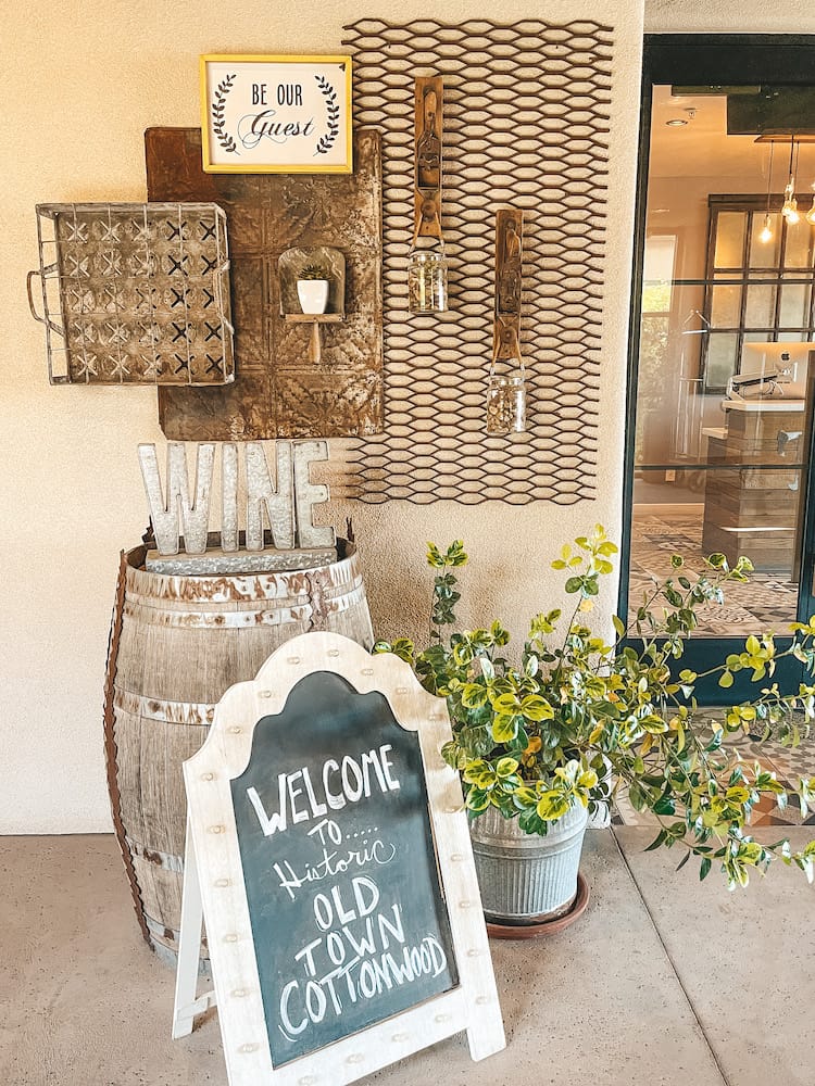 A chalkboard sign that says "Welcome to Old Town Cottonwood" sitting outside the lobby of The Tavern, a hotel in Old Town Cottonwood.