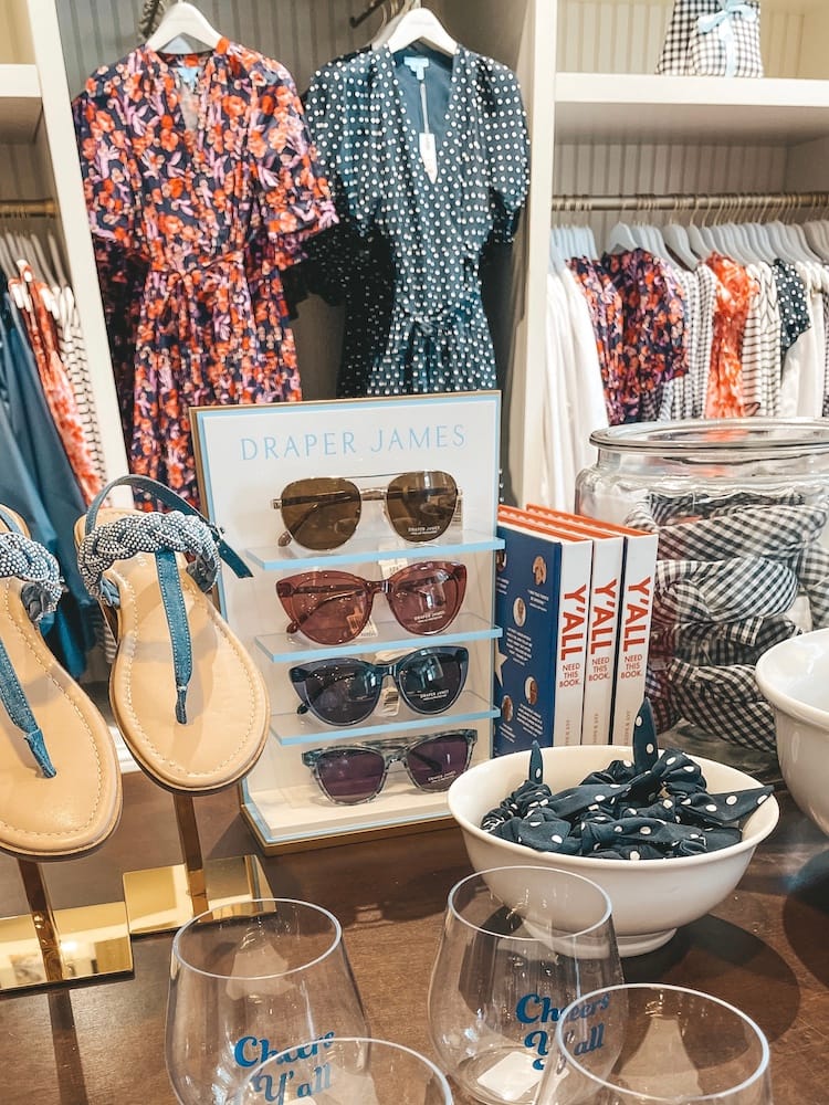 Sunglasses, shoes, dresses, wine glasses, and other clothing and merchandise inside of Draper James in 12 South