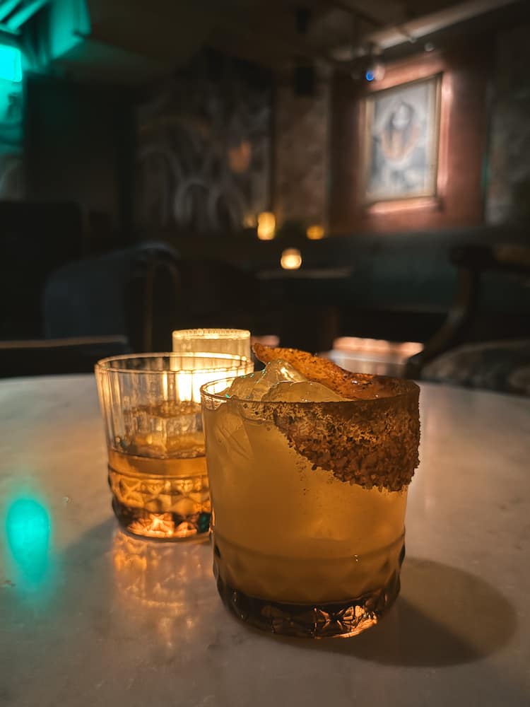 Two cocktails sitting on a table inside Pushing Daisies, an underground margarita bar on Broadway Street in Nashville