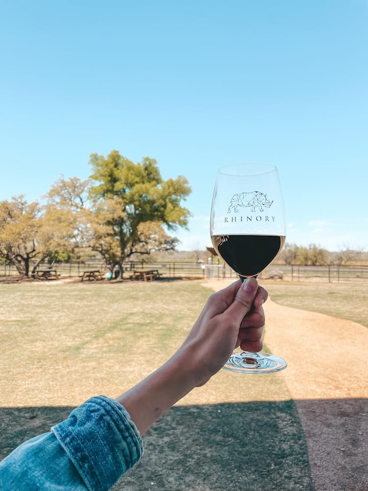 A glass of red wine being held up at the Rhinory during a weekend in Fredericksburg, TX