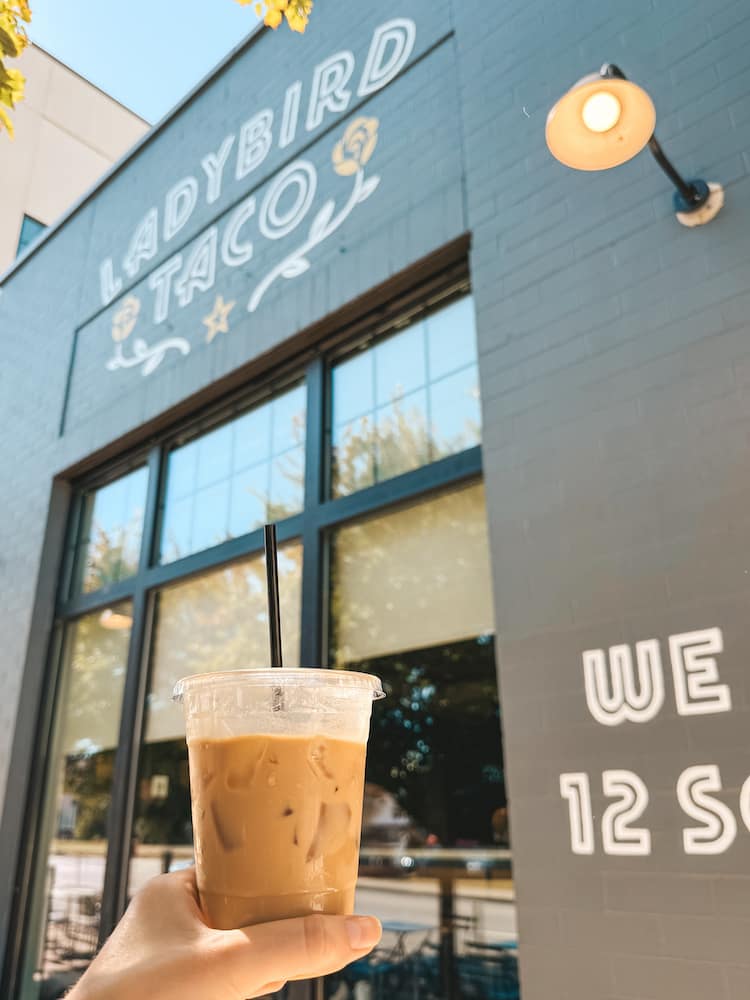 An iced coffee in front of the exterior for Ladybird Taco in 12 South