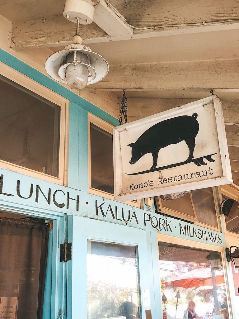 A blue wooden building white a white sign with a black pig on it and letters reading "Kono's Restaurant." This is one of the best places to eat in Oahu.
