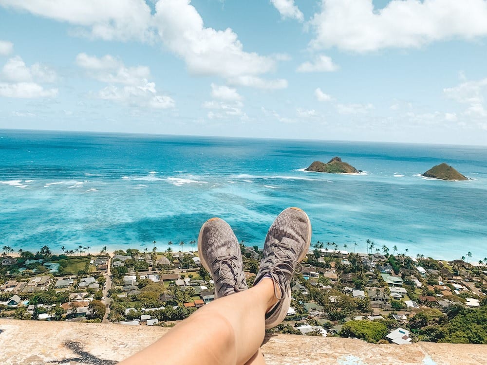 A pair of gray tennis shoes hanging off the ledge of the Lanikai Pillbox hike, one of the best free things to do in Oahu