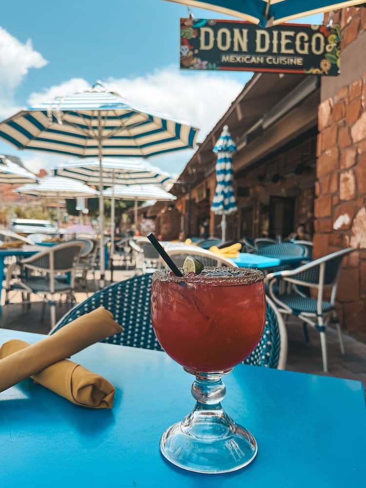 A prickly pear margarita sitting on a blue table at Don Diego Mexican Cuisine in Uptown Sedona