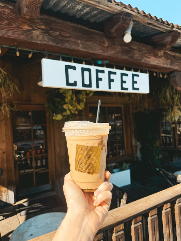 A cup of coffee in front of a coffee sign in a wooden building in Old Town Temecula