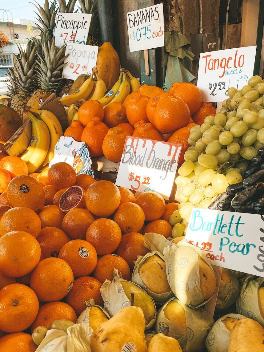 Oranges, grapes, pineapples, bananas, pears, and other fresh fruits in Pike Place Market in Seattle.