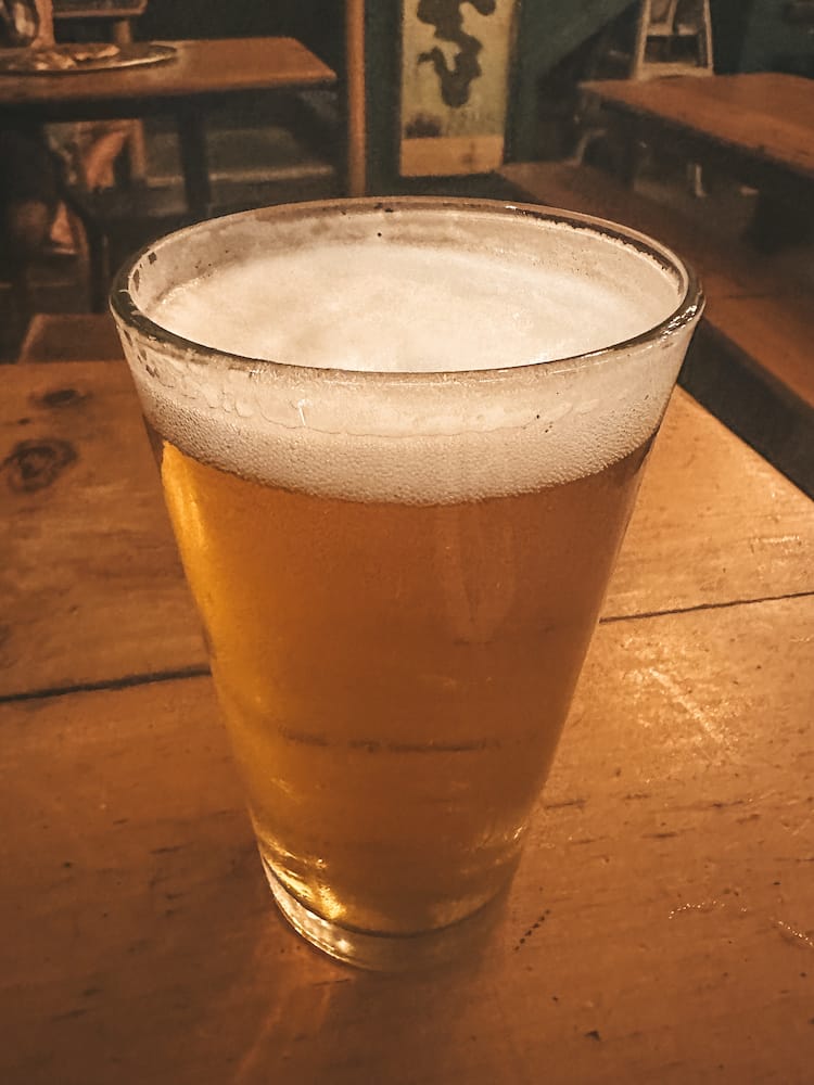 A golden beer sitting on a wooden table in Maui.