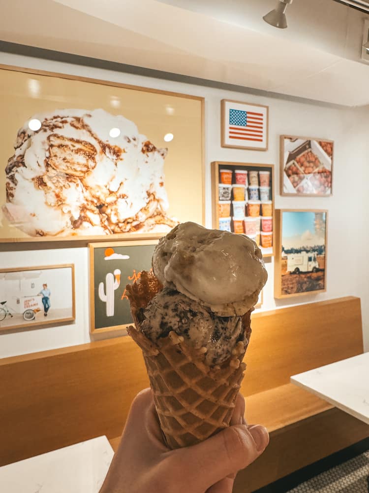 An ice cream cone in front of a colorful mural of photos at an ice cream shop in Old Town Scottsdale.