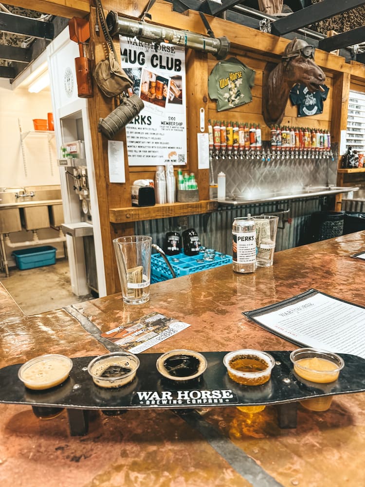 A flight of five beers at War Horse Brewing Co. at Three Brothers Winery in the FInger Lakes, with war-themed memorabilia in the background behind the bar.