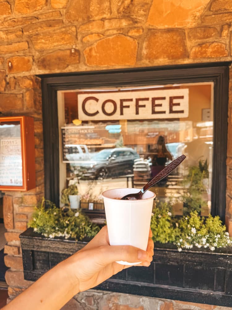 An cup of ice cream and coffee in front of a sign that says "coffee" at a dessert shop in Sedona.