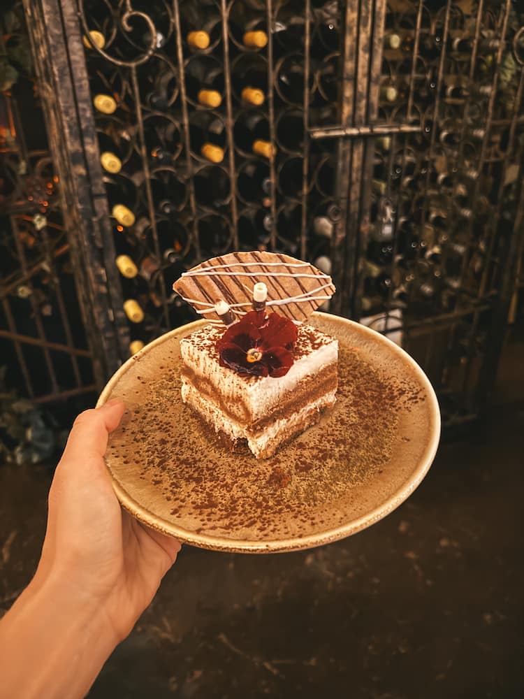 A slice of tiramisu with an edible flower at one of the best restaurants in Sedona