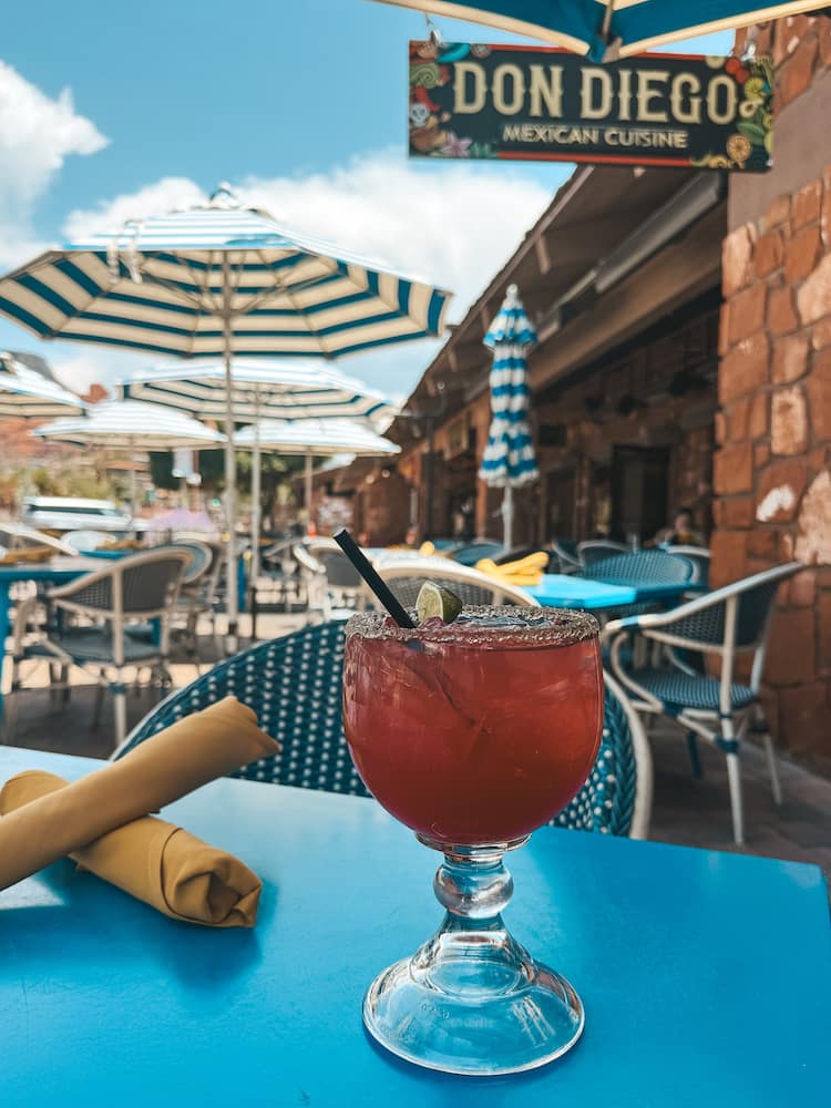 A prickly pear margarita sitting on a blue table at Don Diego Mexican Cuisine in Uptown Sedona