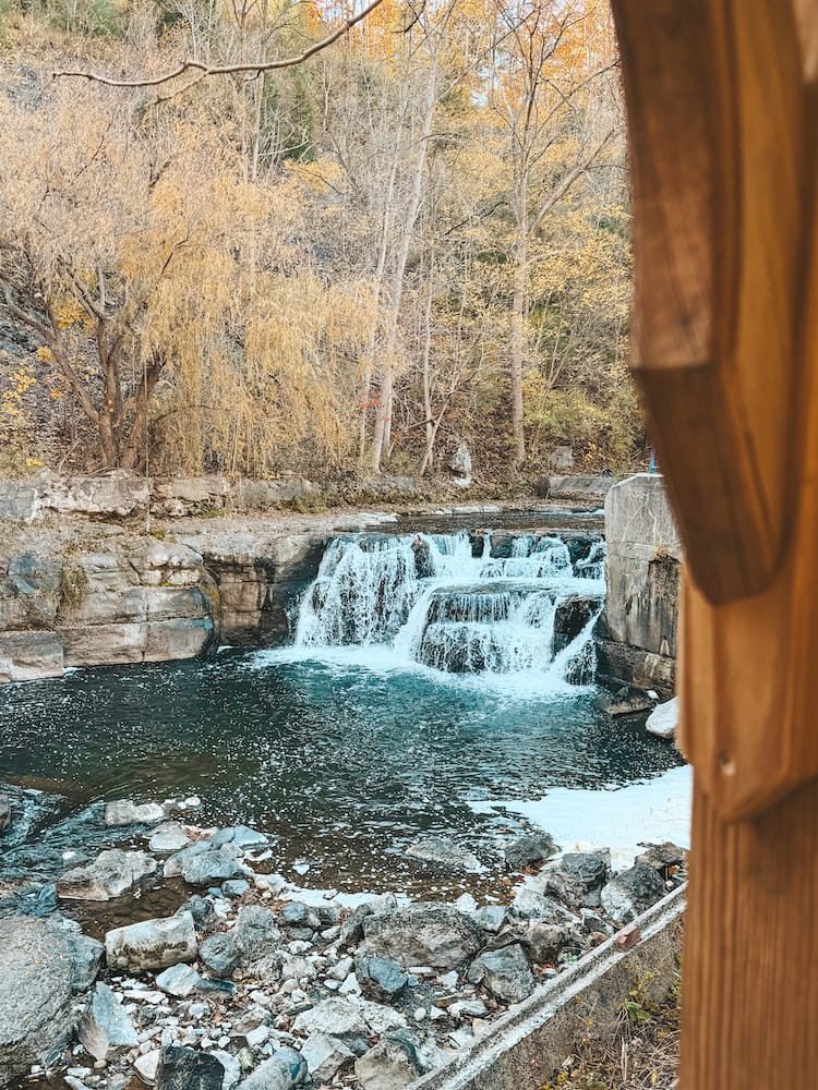 A waterfall cascading into a pool of water along the Keuka Lake Outlet Trail in the Finger Lakes