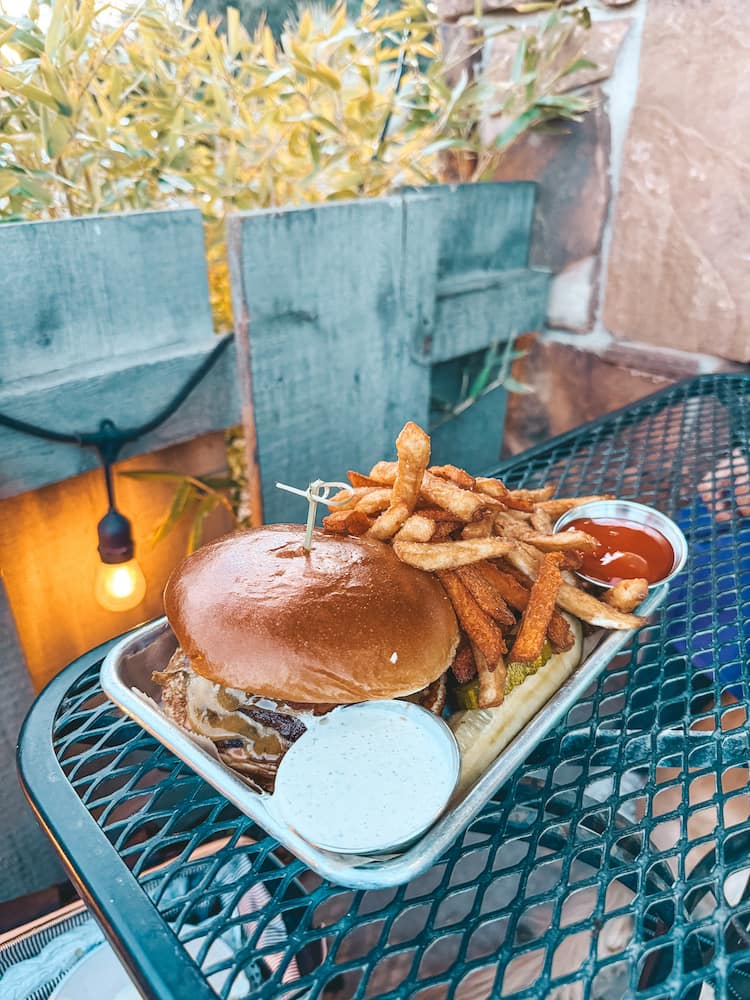 A burger and fries from Sedona Beer Company sitting on a table on the patio of the restaurant