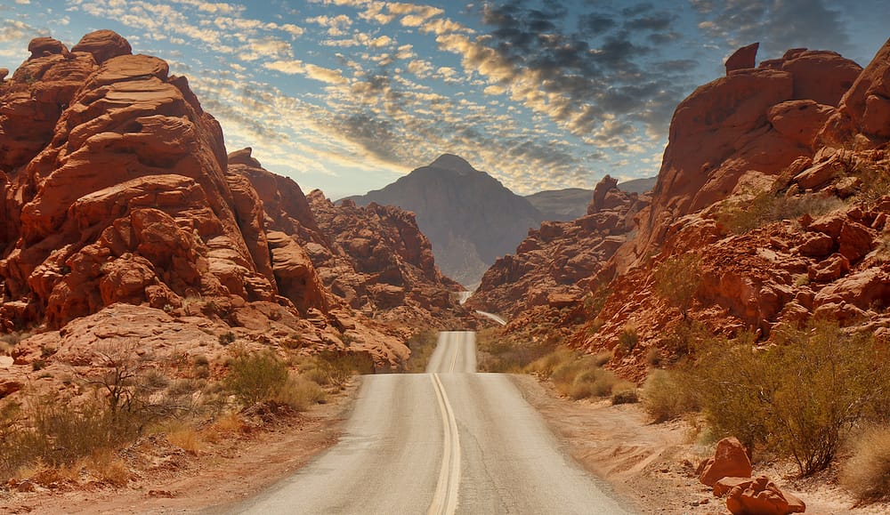 A highway running through the red rocks in Red Rock Canyon.