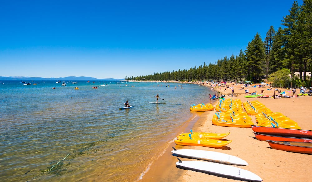 Several kayaks, boats, and paddleboarders at Lake Tahoe in California.