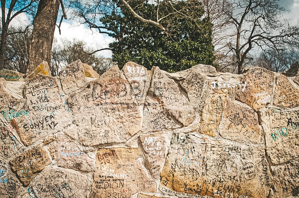 A wall in Memphis outside of Graceland with graffiti on it.