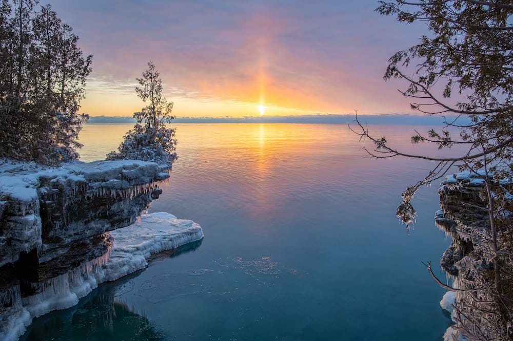 An icy landscape and sunset over the water in Door County, Wisconson