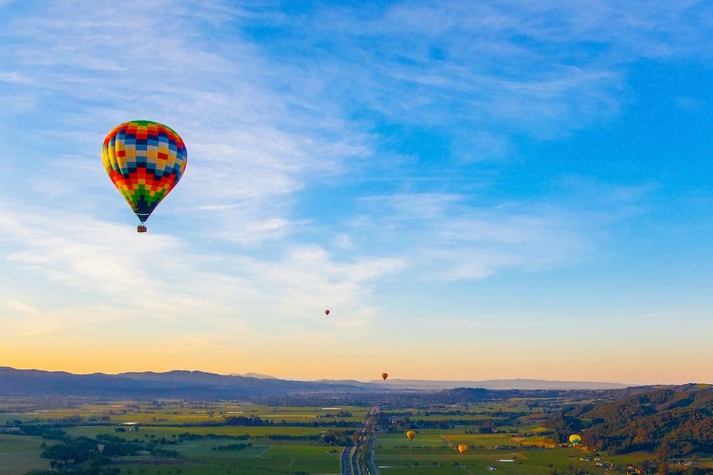 A hot air balloon soaring over the wine country in Napa Valley, one of the best places to visit in February in the USA