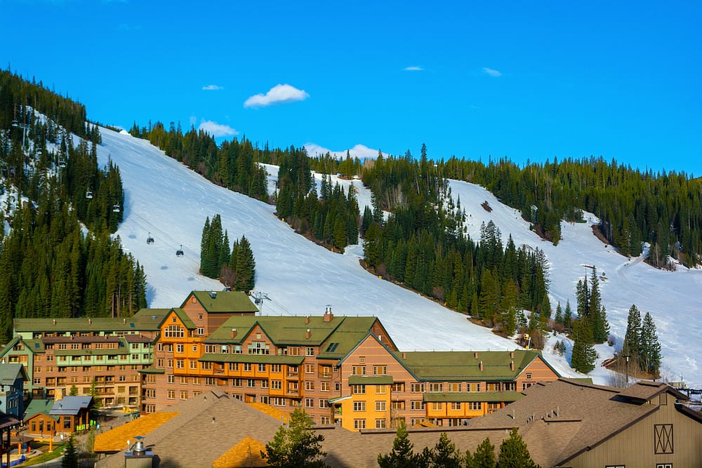 Winter Park Resort is in the foreground with snowy slopes and green trees in the background.