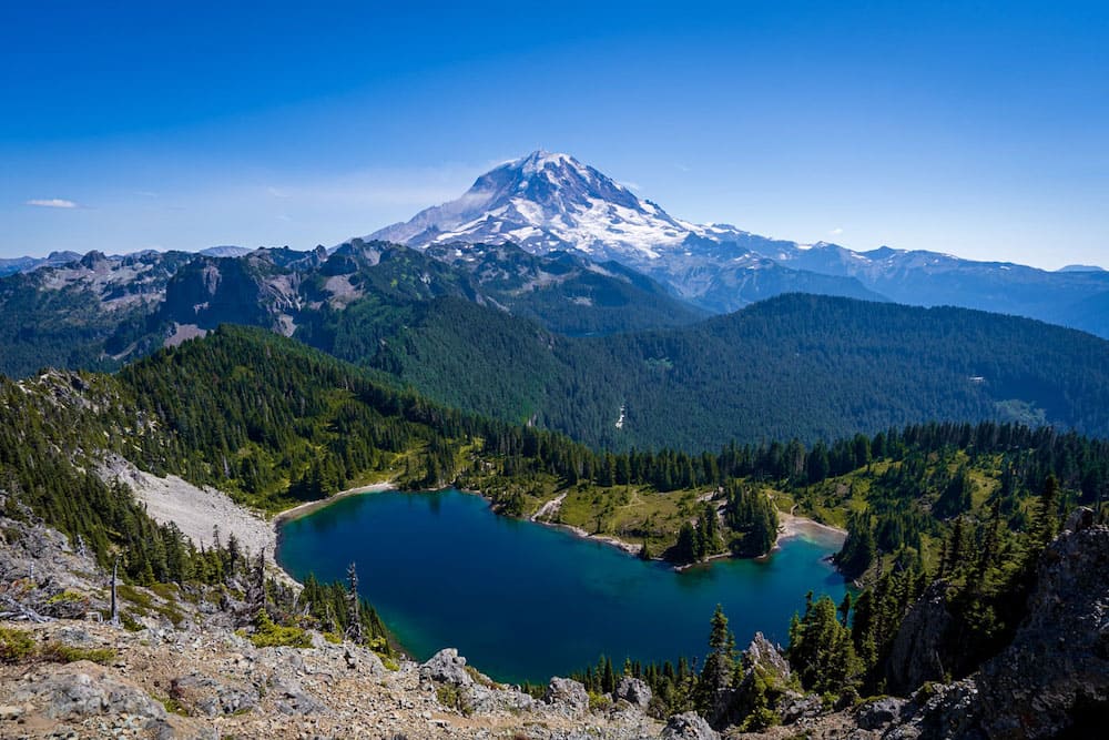 Mount Ranier behind a blue lake and gorgeous greenery