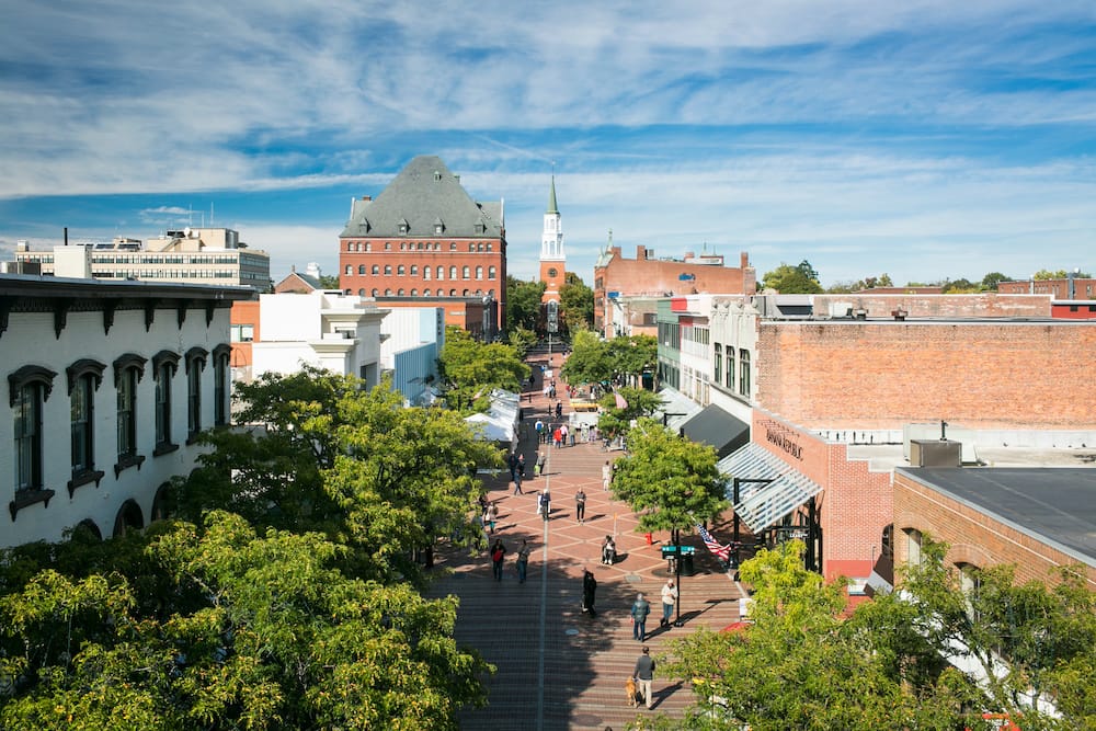 Burlington, Vermont, featuring storefronts, people walking, a church, and trees from an aerial point of view