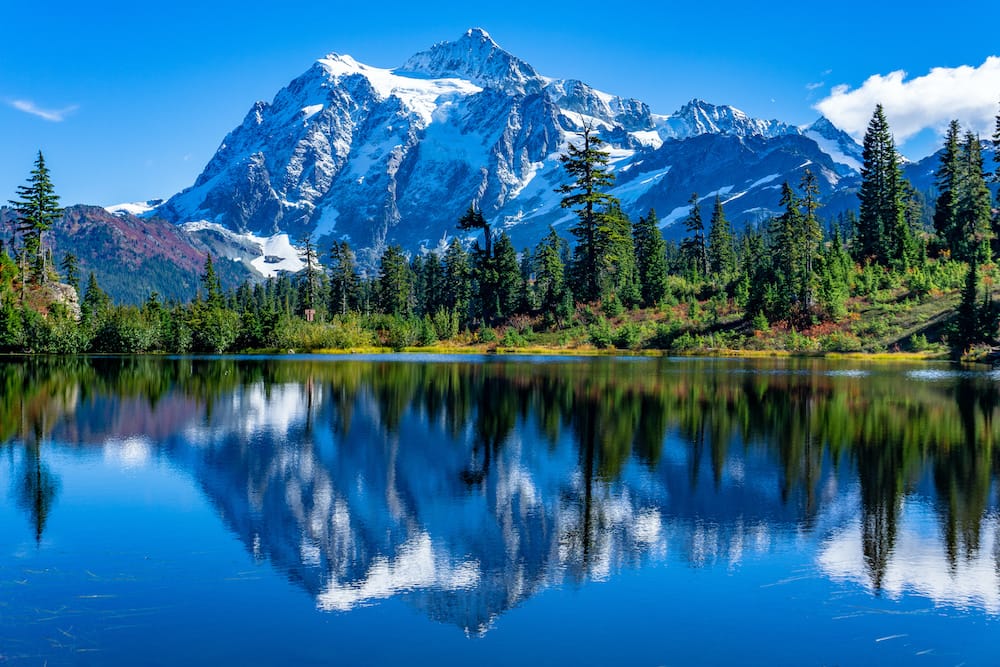 Snowcapped mountains in the background reflecting on a lake in Rocky Mountain National Park in Colorado