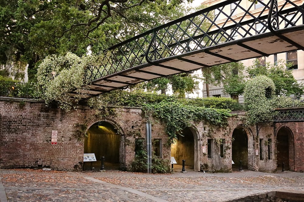 A brick and stone building covered in greenery in Savannah, Georgia