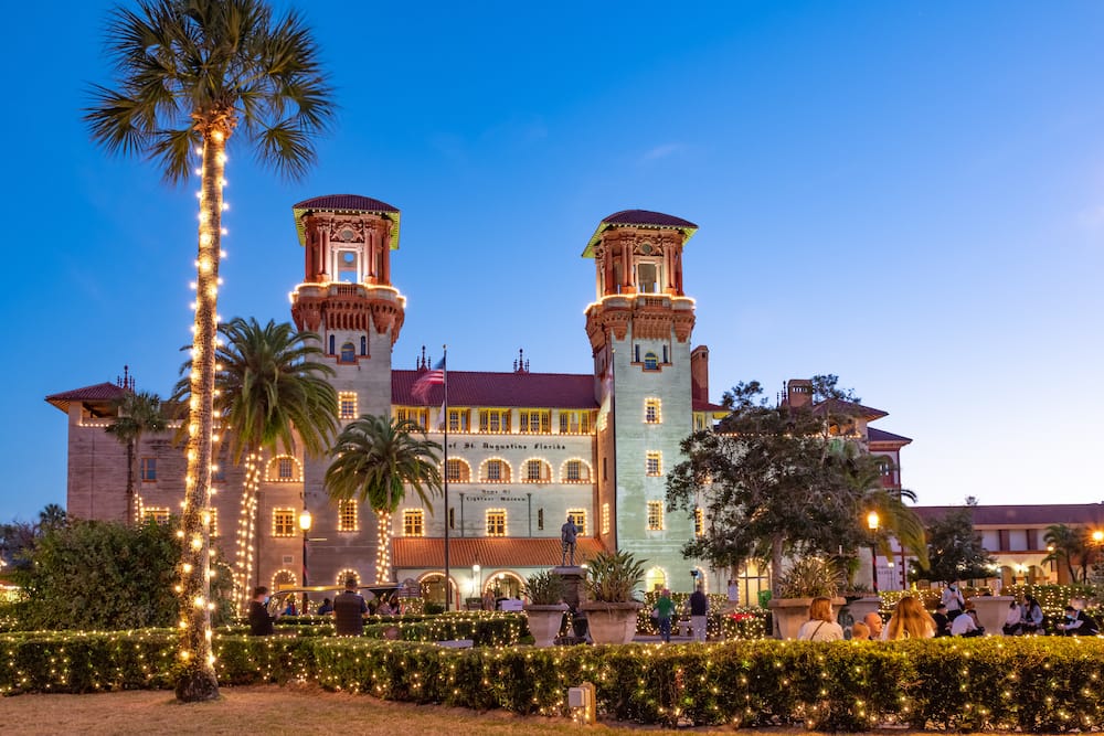 A beautiful historic building in St. Augustine lit up for the holiday season at dusk.