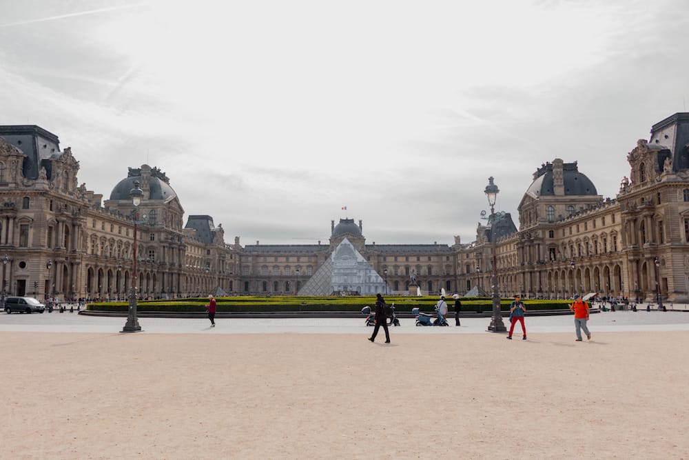 The historic buildings and glass triangle that houses the Louvre Museum, one of the best places to visit during a weekend in Paris.