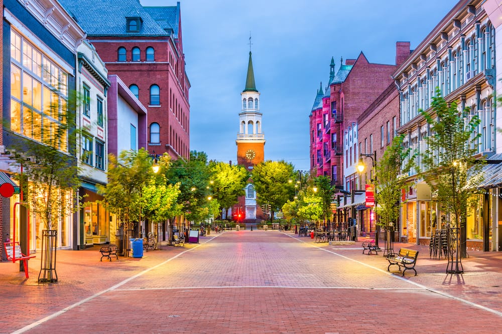 Burlington, Vermont, USA, at Church Street Marketplace with a church, red brick streets, and historic shops.