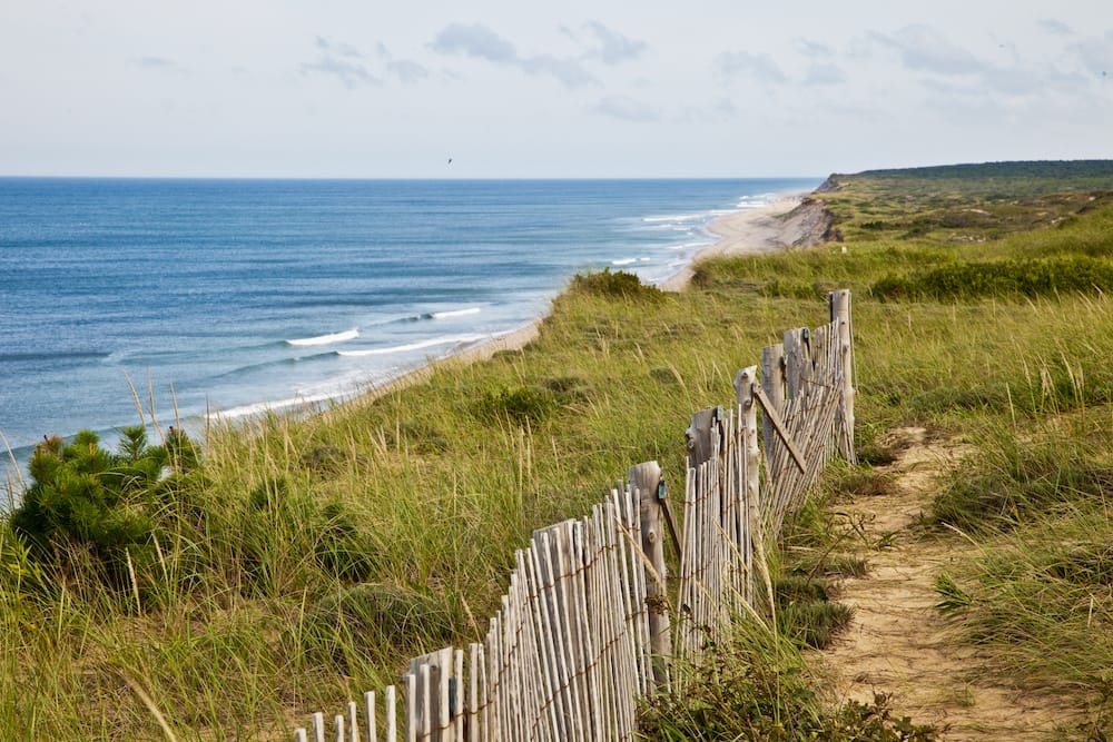 A wooden fence along Marconi Beach in Cape Cod, one of the best places to visit in the USA in July