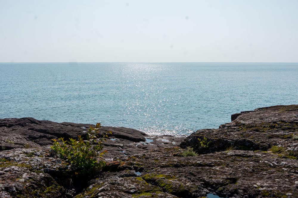 A flat, rocky outcropping overlooking a peaceful expanse of blue ocean in Duluth, Minnesota – one of the best places to visit in the USA in July.