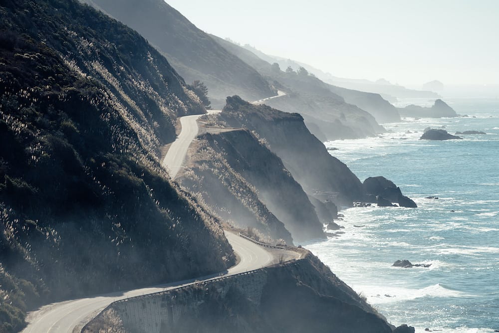A view of the Pacific Coast Highway in Big Sur running past the ocean.