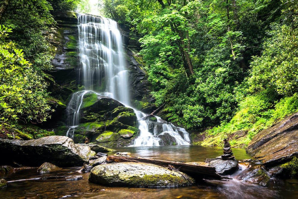 A waterfall just outside Asheville, North Carolina, surrounded by greenery and lakes.