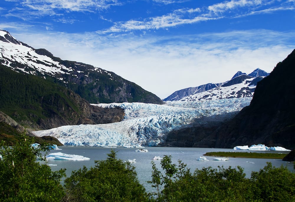 A view of Mendenhall Glacier in Juneau, Alaska, surrounded by mountains.