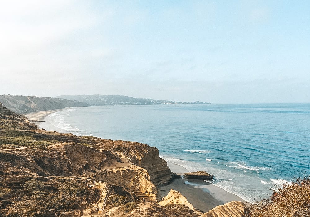 Rocky cliffs, the beach, and the ocean from an aerial view in San Diego.