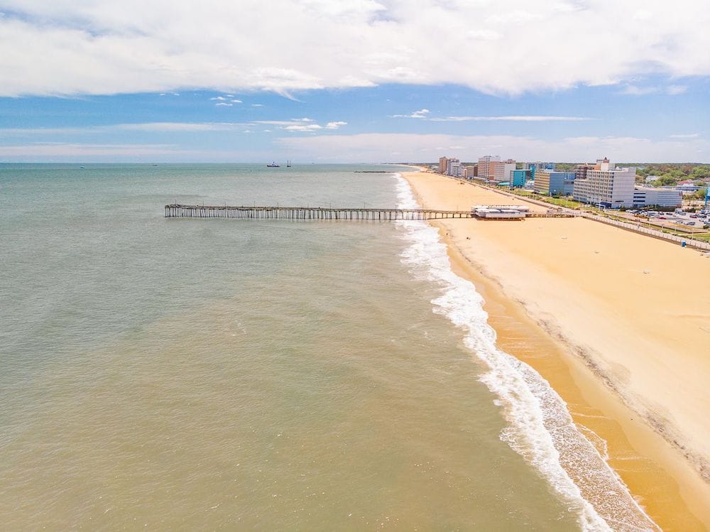 An aerial view of Virginia Beach featuring a pier, hotels, and the beach