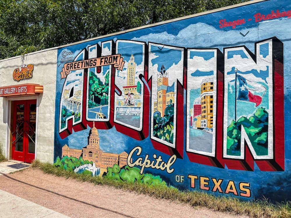 A colorful mural that reads "Greetings from Austin" and looks just like a postcard. Austin is one of the best places to visit in February in the U.S.