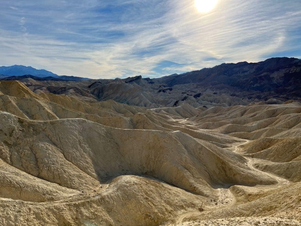 The mountainous terrain in Death Valley National Park in front of a blue sky.