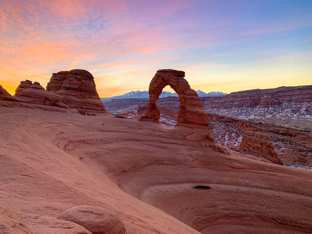 Moab is one of the best places in the USA to visit in March to see the Delicate Arch at sunset, like in this photo.