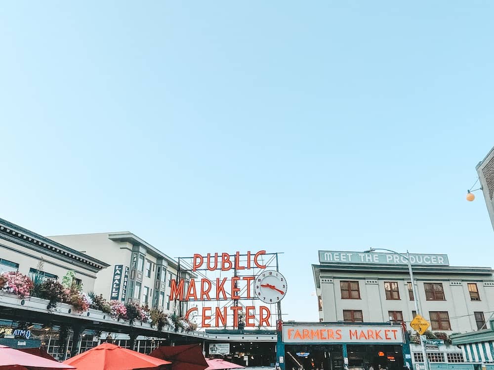 The neon red Pike Place Public Market sign and tops of the buildings in Seattle, Washington – one of the best places to visit in the USA in July.