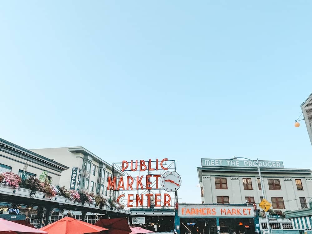 Pike Place Market in Seattle, with red umbrellas and flowers surrounding the market.